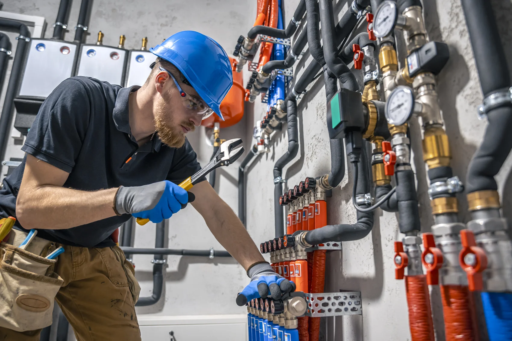 NYC plumber servicing a backflow preventer and valves in a plant room